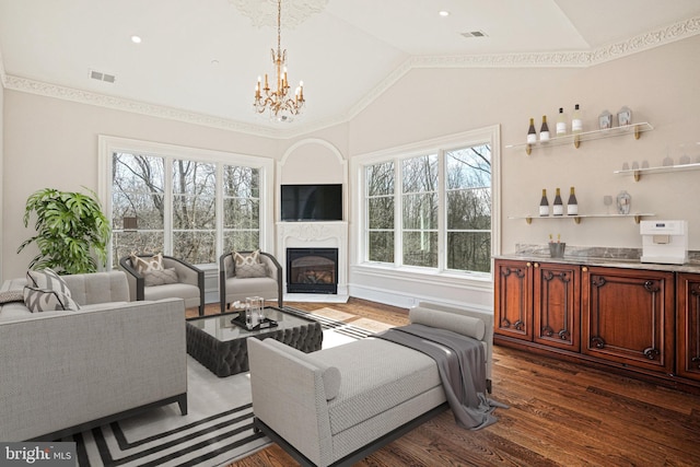 living room with lofted ceiling, a chandelier, plenty of natural light, and dark hardwood / wood-style flooring