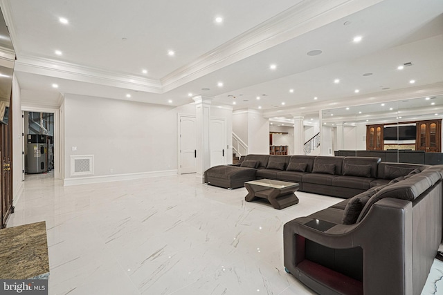 living room featuring ornamental molding, water heater, ornate columns, and a raised ceiling