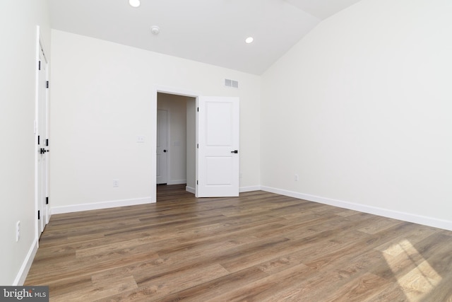 unfurnished bedroom with vaulted ceiling and dark hardwood / wood-style floors