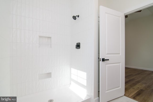 bathroom featuring hardwood / wood-style floors and tiled shower