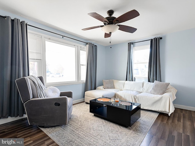 living room featuring dark wood-type flooring and ceiling fan