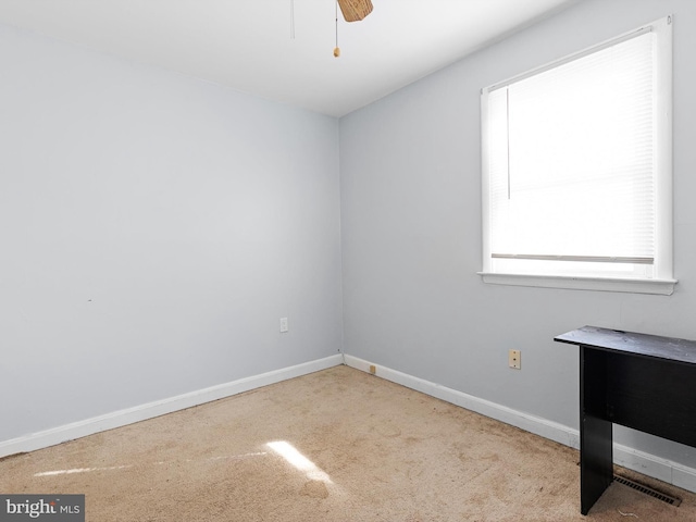 carpeted spare room featuring ceiling fan