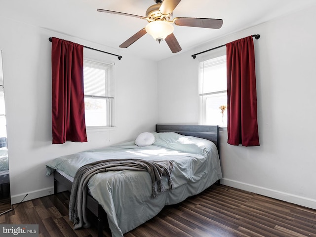 bedroom with multiple windows, ceiling fan, and dark hardwood / wood-style flooring