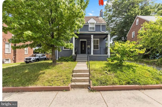 view of front facade featuring a front lawn and covered porch