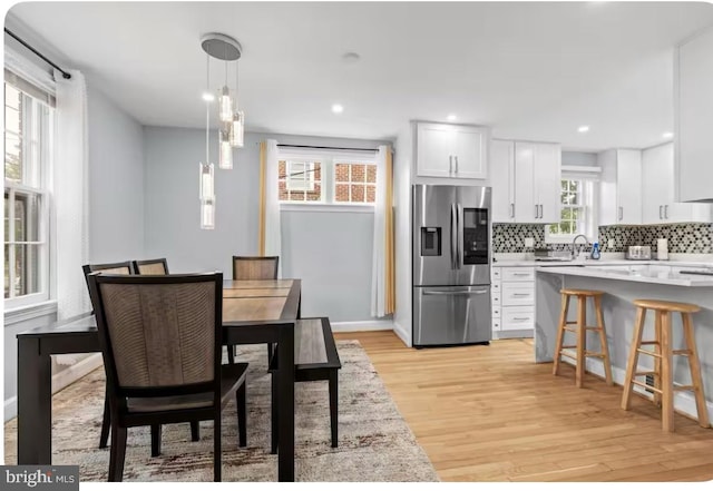 dining area with light hardwood / wood-style floors and a healthy amount of sunlight