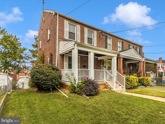 view of front of house featuring a front yard, a storage unit, and a porch