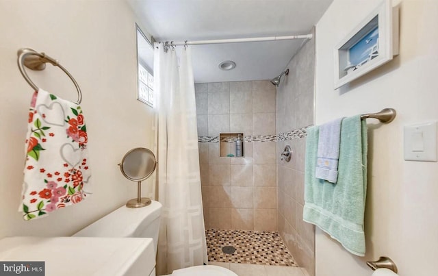 bathroom with toilet and a shower with shower curtain