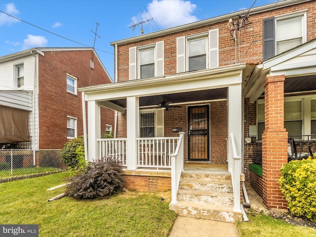 view of front of home with covered porch, a front lawn, and ceiling fan