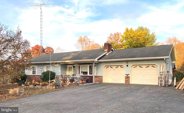 single story home with a porch and a garage