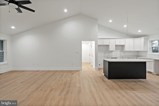 kitchen with ceiling fan, a center island, light wood-type flooring, and white cabinetry