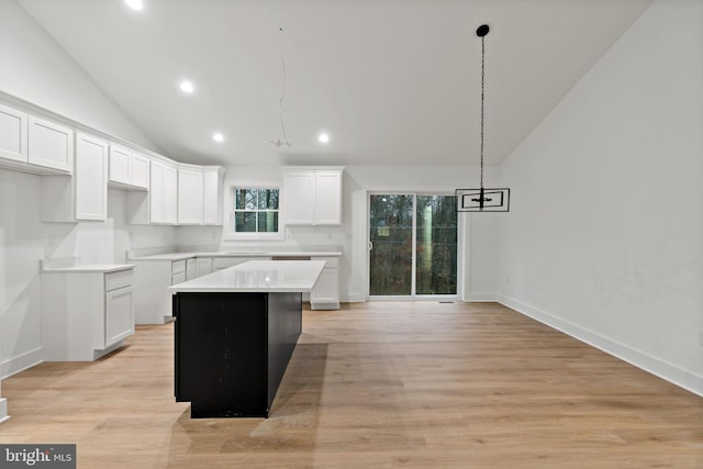 kitchen with a center island, white cabinetry, and hanging light fixtures