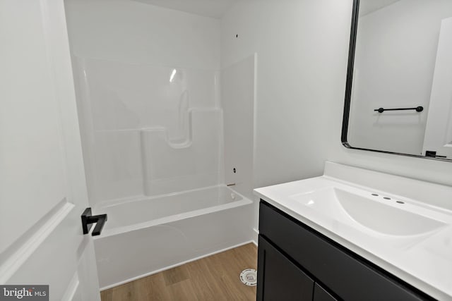 bathroom featuring vanity, hardwood / wood-style flooring, and  shower combination