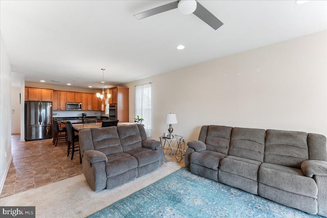 living room with ceiling fan with notable chandelier