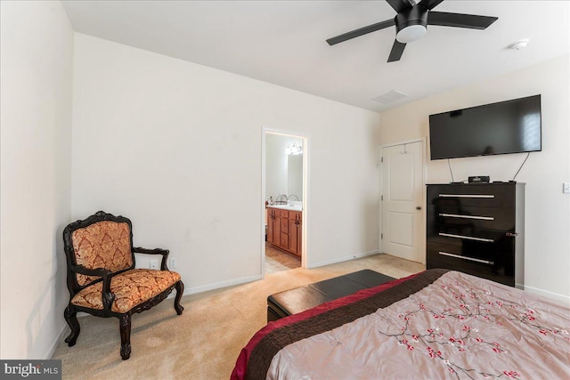 bedroom with ceiling fan, ensuite bathroom, and light carpet