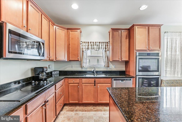 kitchen featuring dark stone counters, sink, and stainless steel appliances