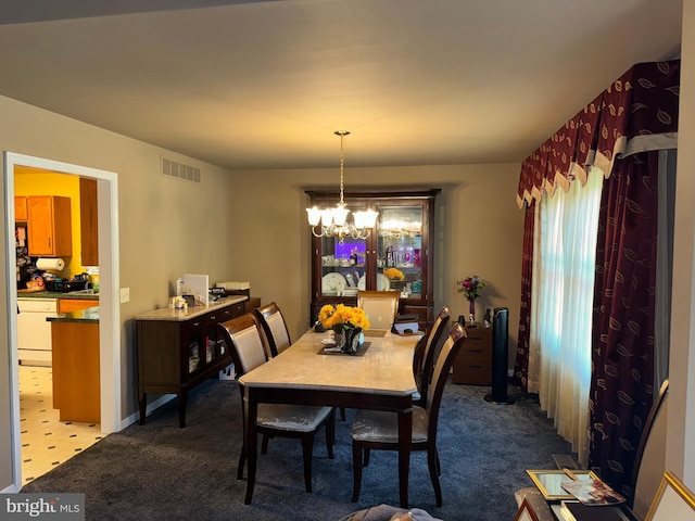 carpeted dining area featuring a notable chandelier