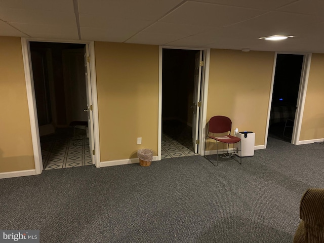 basement with carpet floors and a paneled ceiling