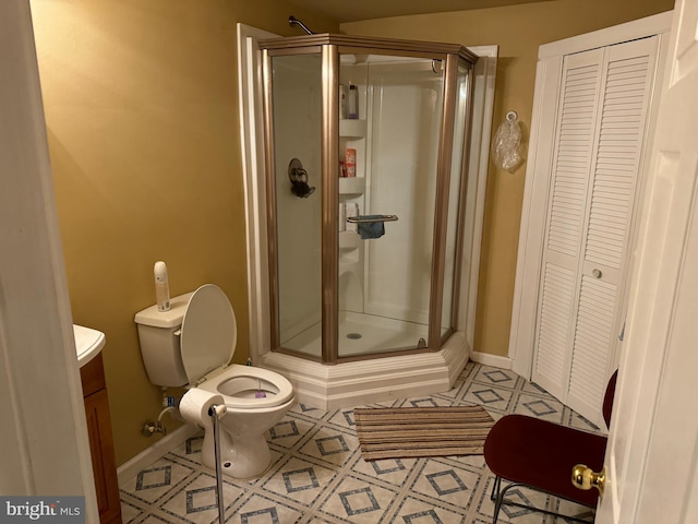 bathroom with vanity, toilet, tile patterned floors, and a shower with shower door