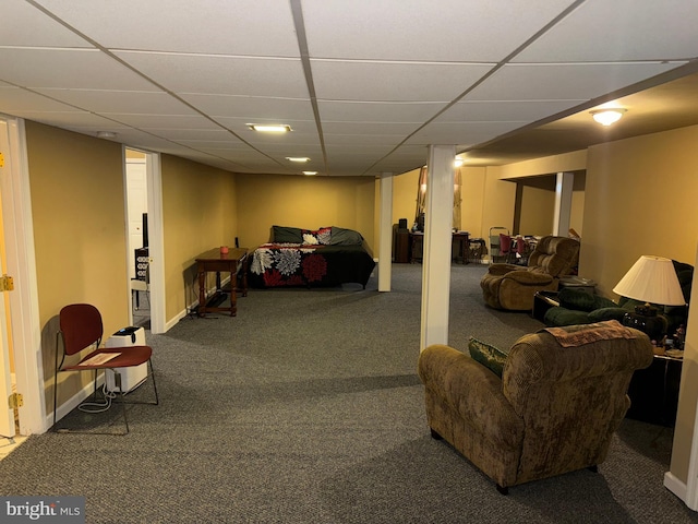 basement featuring a paneled ceiling and carpet flooring