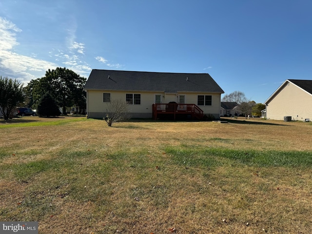 rear view of house featuring a yard and a deck