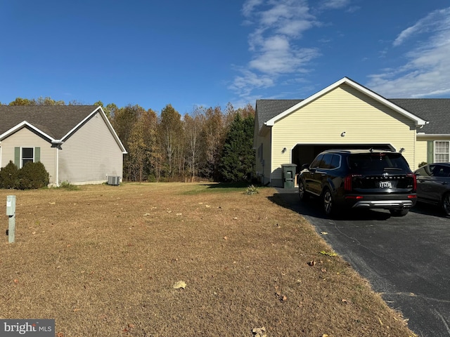 view of side of property featuring central air condition unit and a garage