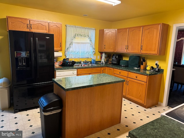 kitchen with sink, a kitchen island, black fridge, and dishwasher