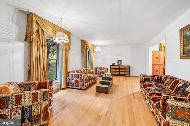 living room with hardwood / wood-style flooring and a notable chandelier