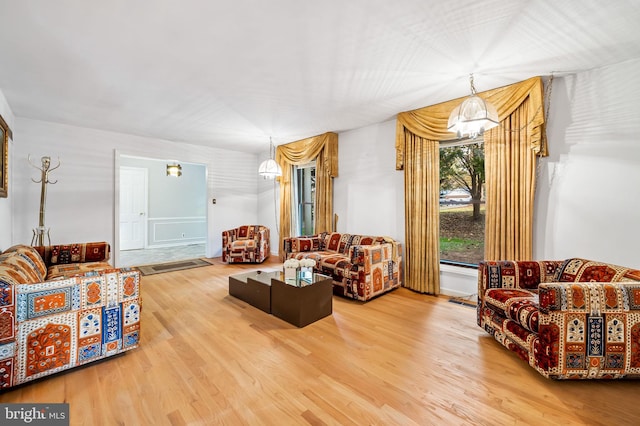 living room featuring wood-type flooring and a notable chandelier