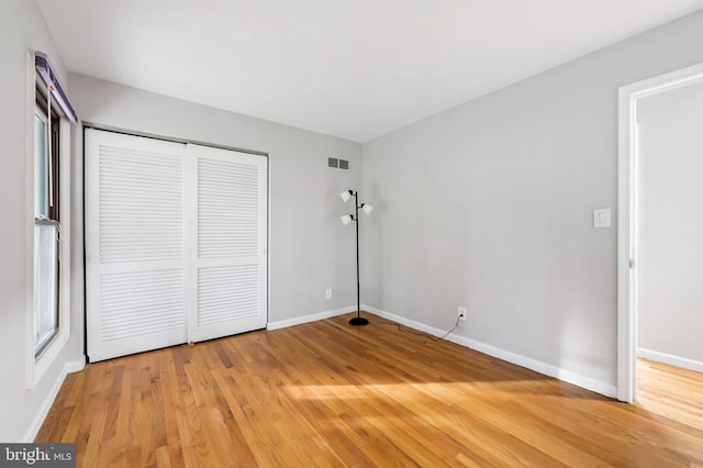 unfurnished bedroom featuring a closet and hardwood / wood-style floors