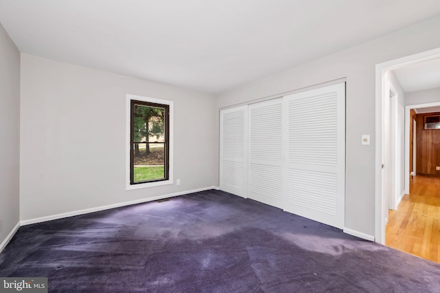 unfurnished bedroom with a closet and dark carpet