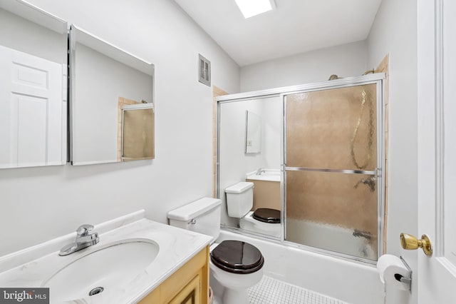 full bathroom with toilet, tile patterned floors, vanity, and shower / bath combination with glass door