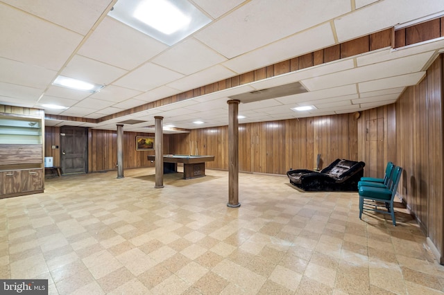 basement with wooden walls and a drop ceiling