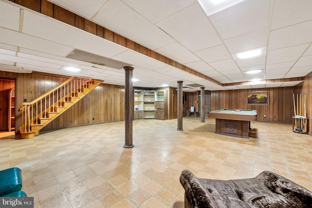 basement with wood walls, pool table, and a paneled ceiling