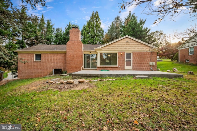 back of property featuring a patio and a yard