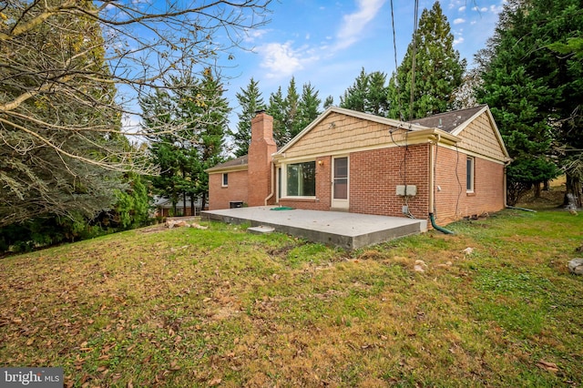 rear view of property featuring a patio area and a yard