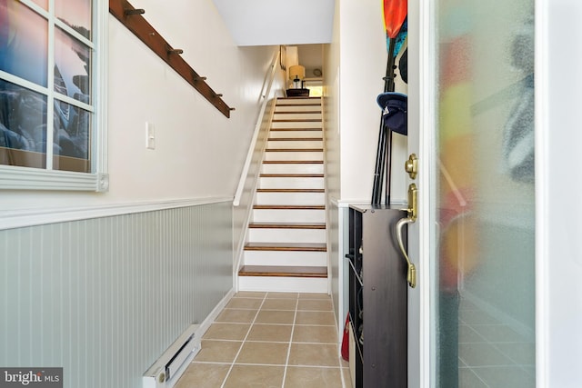 stairs featuring tile patterned flooring and a baseboard radiator