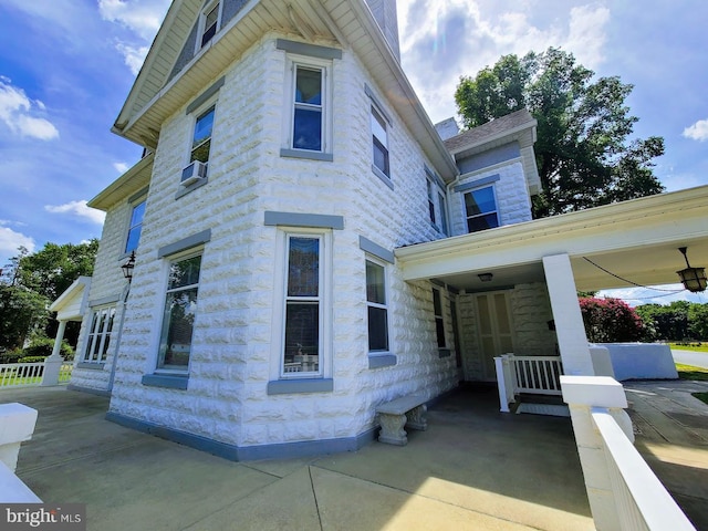 view of side of property with cooling unit and a porch