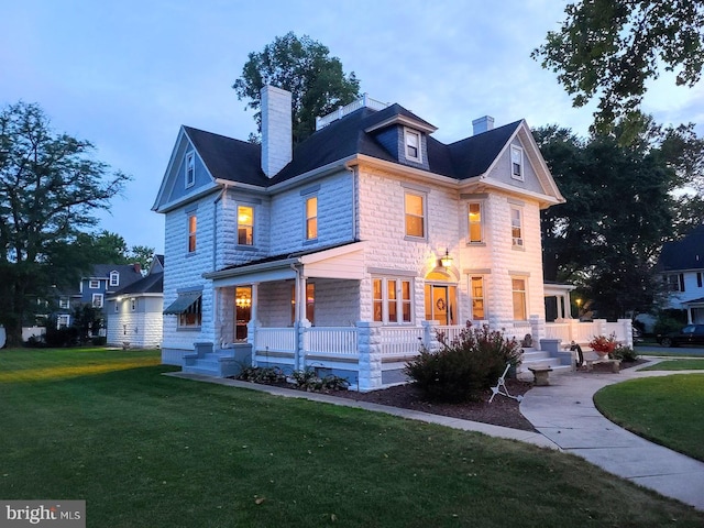 view of front of house with a front yard and covered porch