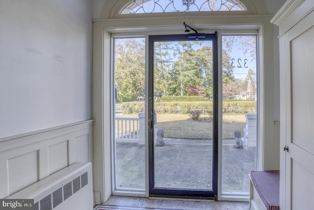 doorway to outside featuring a healthy amount of sunlight and radiator