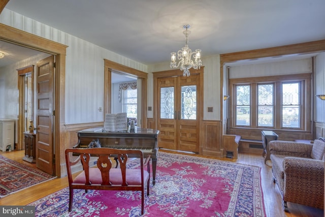 foyer entrance featuring hardwood / wood-style floors, plenty of natural light, and an inviting chandelier