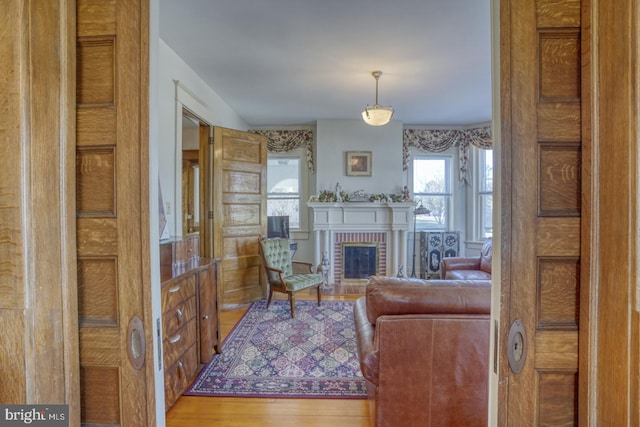 living room with a brick fireplace and hardwood / wood-style floors