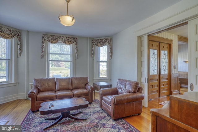 living room with a wealth of natural light and light hardwood / wood-style flooring