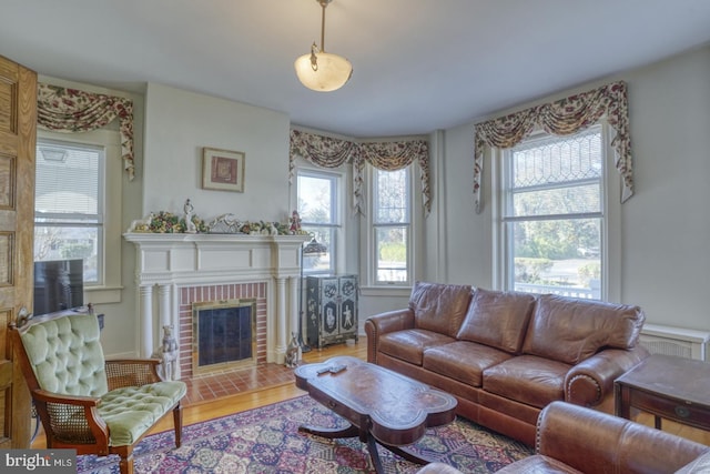 living room featuring hardwood / wood-style floors and a brick fireplace