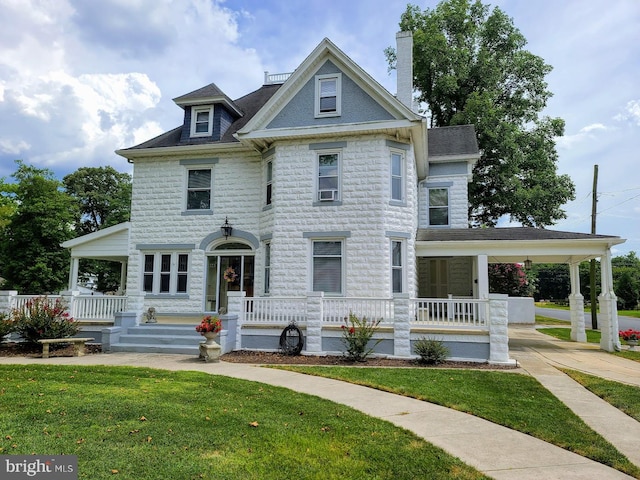 victorian home featuring a porch and a front lawn