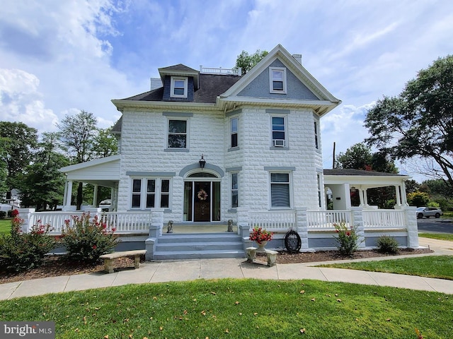 victorian home with a front lawn and a porch