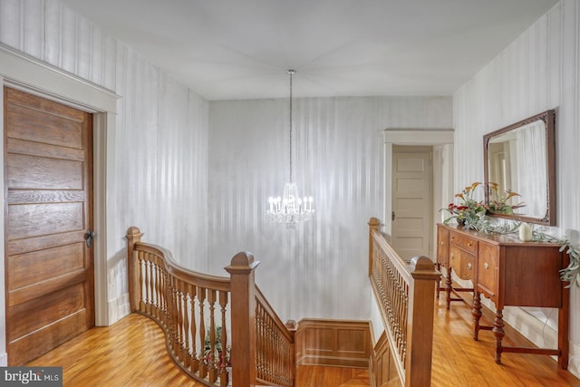 stairs with an inviting chandelier and wood-type flooring