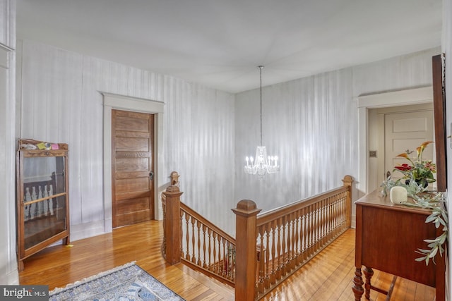 hallway featuring wood-type flooring and a chandelier