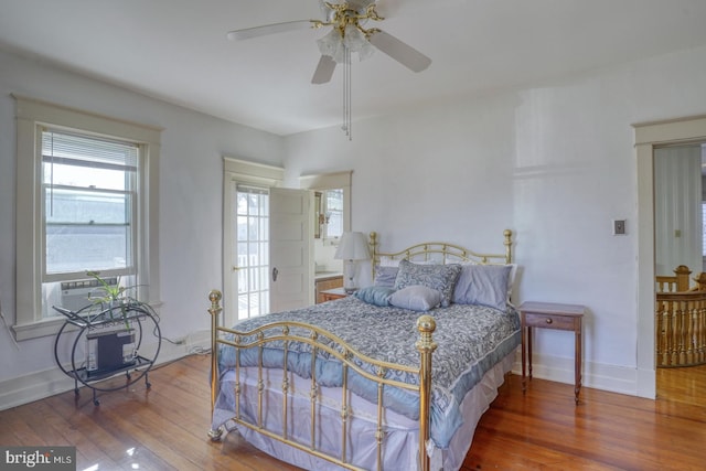 bedroom featuring hardwood / wood-style flooring, ceiling fan, connected bathroom, and cooling unit