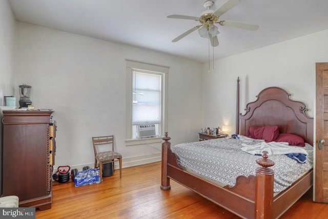 bedroom featuring hardwood / wood-style floors, cooling unit, and ceiling fan