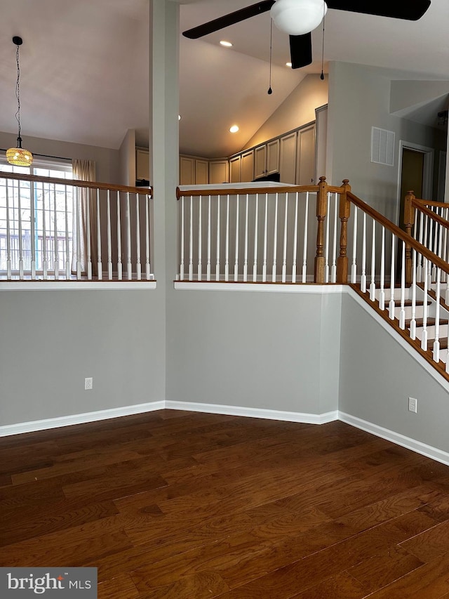 interior space featuring dark hardwood / wood-style flooring, lofted ceiling, and ceiling fan